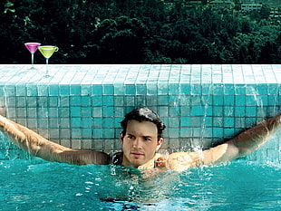 topless man on swimming pool at daytime